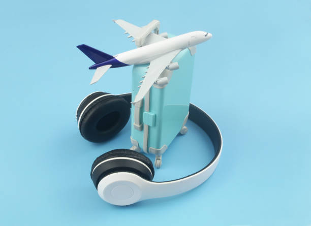 istock Airplane model with wireless headphones and travel suitcase 1415332645
