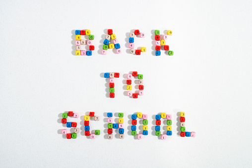 Text Back To School made of colourful number beads on white background. Back to school concept. Flat lay, top view.