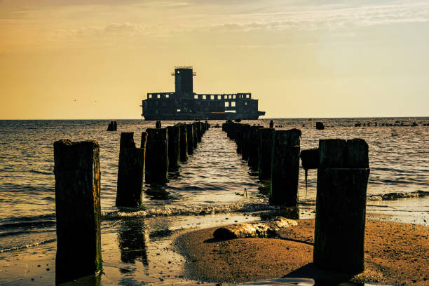 istock Old ruined wooden pier and a sandy beach 1415339834