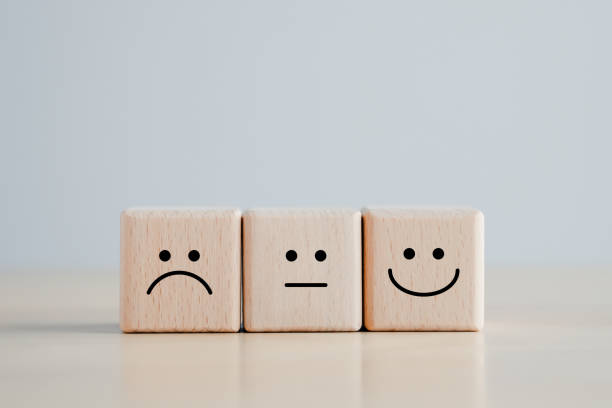 istock Customer service rating experience and feedback emotion and satisfaction survey concept. wood cube with smile, normal and sad face. Negative, neutral and positive facial expressions. 1415340200