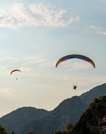 Antalya Province, Turkey - October 23, 2020: Paragliders flying from a top of Tahtali mountain near Kemer, Antalya Province in Turkey. Concept of active lifestyle and extreme sport adventure