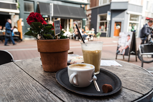 Cup and coffee and glass of iced coffee in sidewalk cafe in the historic centre of Haarlem, Netherlands