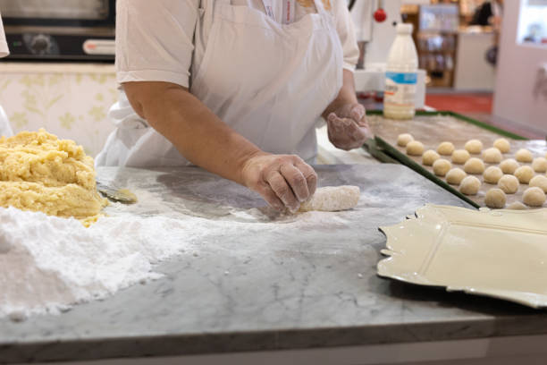 istock Working with Hands of Uncooked Dough with Flour and Eggs for Making Round Cakes 1415341380