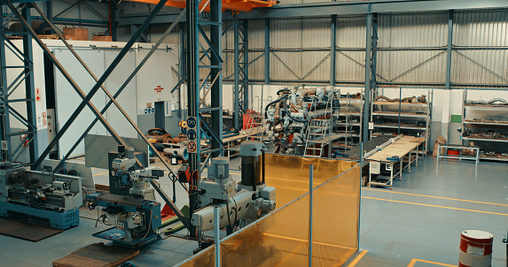 Empty mechanical engineering workshop, factory and warehouse with heavy machinery and equipment from above. Manufacturing and production of metal, steel and alloy gear for industrial and building use