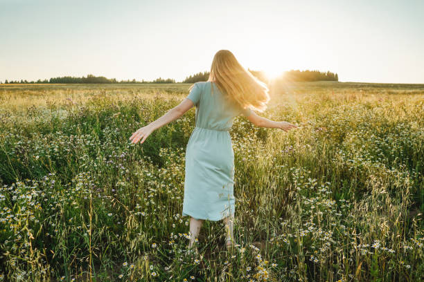 istock Woman dance in the field on sunset. 1415343120