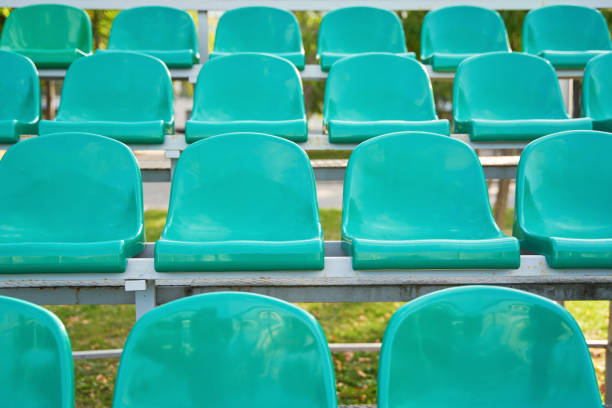 istock Empty turquoise plastic seats on stands of stadium in open. 1415344596