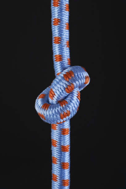 istock Colored ropes tied in a knot on a black background 1415344895