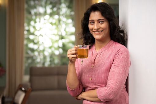 istock Young woman drinking cup of herbal tea at home stock photo 1415347093
