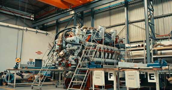 Industry, tech and an engine in a warehouse. Parts in a storehouse or factory getting ready to be repaired or shipped out. Machine, industrial and construction plant with technology getting recycled.