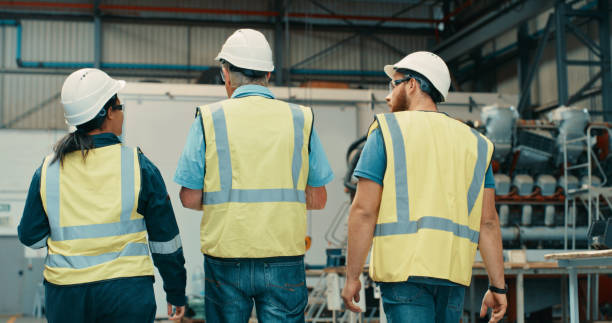 istock Walking and talking group of engineers planning future inspection logistics for development of warehouse. Diverse team mechanics and technicians discussing project at factory. 1415349633