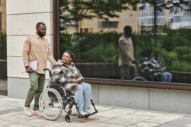 istock Man Assisting Partner with Disability in City 1415350083