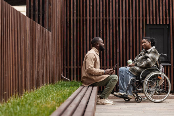 Couple with Partner in Wheelchair Chatting Outdoors