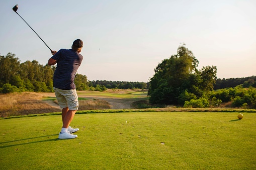 Man playing golf in summer.