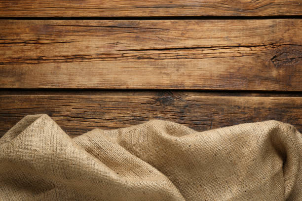 istock Natural burlap fabric on wooden table, top view. Space for text 1415352739