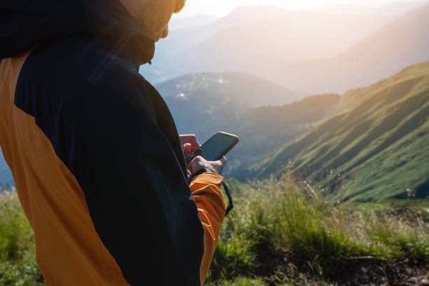 istock Hiker uses smartphone in the mountains at sunset 1415352936