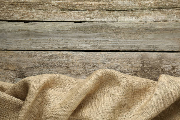 istock Natural burlap fabric on wooden table, top view. Space for text 1415353682