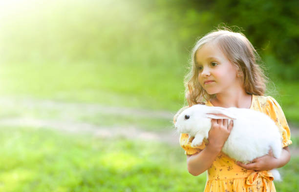 istock a little girl with a white rabbit 1415354090