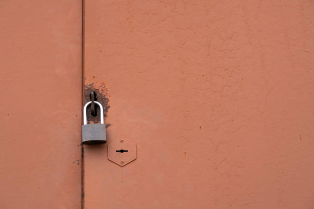 Brown metal door with 2 locks: built-in and padlock. Copy space for text