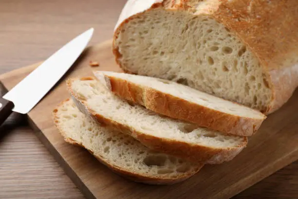 Cut tasty wheat sodawater bread on wooden table, closeup