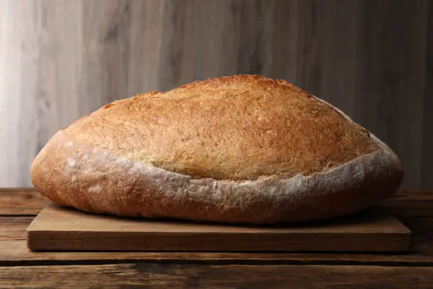 Loaf of tasty wheat sodawater bread on wooden table