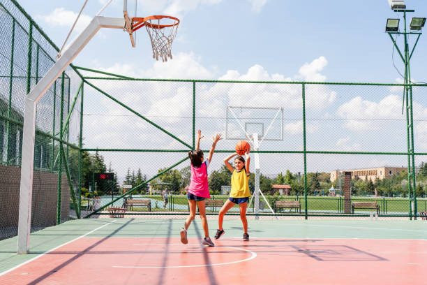 istock Two girls playing basketball outside 1415355927