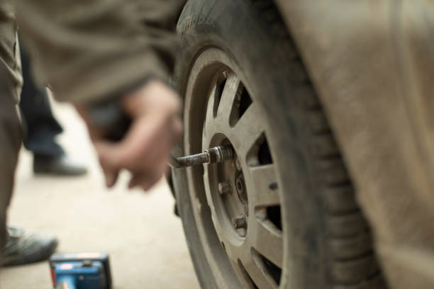 istock Nut on wheel. Lever to replace wheel on car. Hand holds key. 1415356004