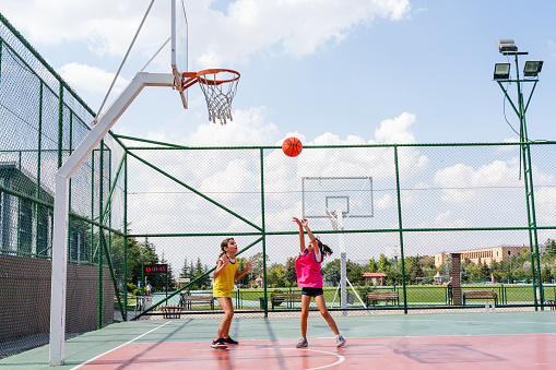 Two girls playing basketball outside