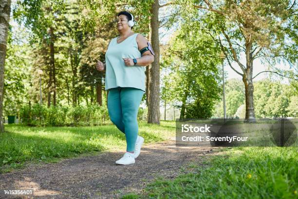 Overweight Woman Running In Park Stock Photo - Download Image Now - Exercising, Walking, Relaxation Exercise