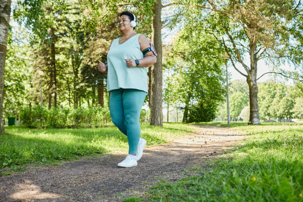 kobieta z nadwagą biegająca w parku - senior adult relaxation exercise healthy lifestyle exercising zdjęcia i obrazy z banku zdjęć