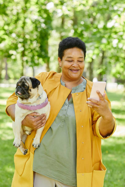 istock Woman Taking Selfie with Dog in Park 1415356443
