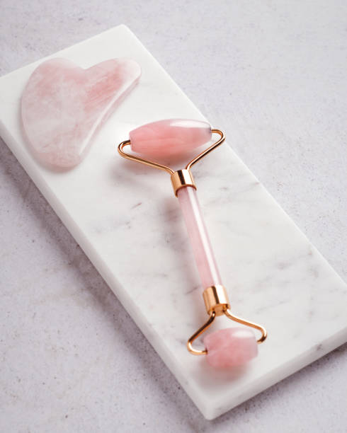 istock Facial roller, gua sha on marble podium, top view 1415356571