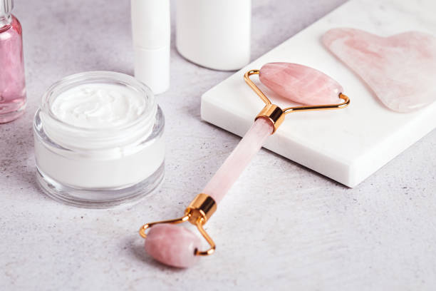 istock Facial roller, gua sha, serum and moisturizing cream on marble background 1415356586