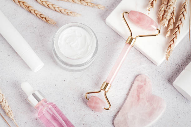 istock Facial roller, gua sha, serum and moisturizing cream on marble background 1415356594