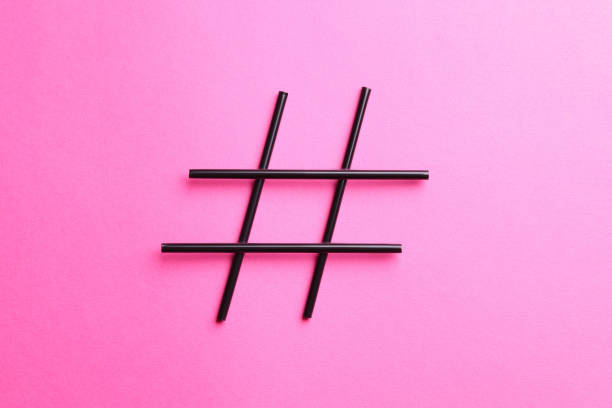 Hashtag symbol made of drinking straws on pink background, top view