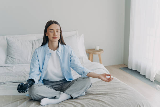 istock Meditation and concentration. Morning routine of disabled woman with artificial cyber limb. 1415357465