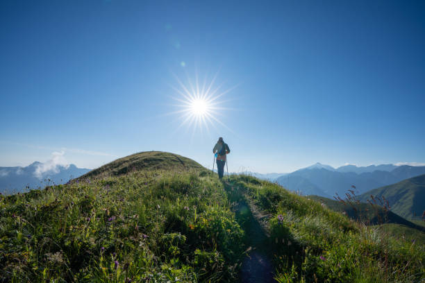 istock Hiker walks alone at mountain range to mountain summit at sunset 1415357701