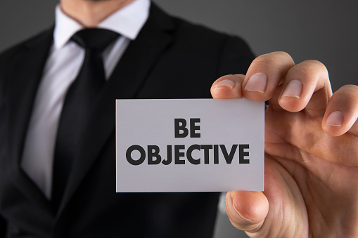 Businessman is holding be objective business card