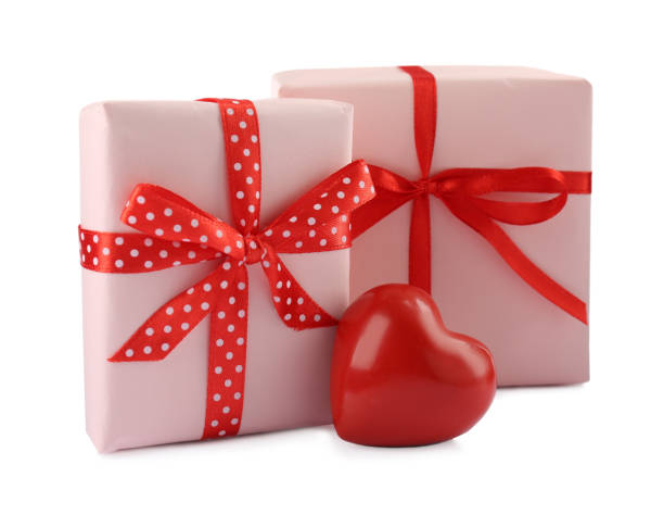 istock Beautiful gift boxes with decorative red heart isolated on white 1415359560