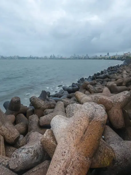Photo of Shot Of Marine Drive Rocks And Sea Water With Cloudy Sky In Mumbai