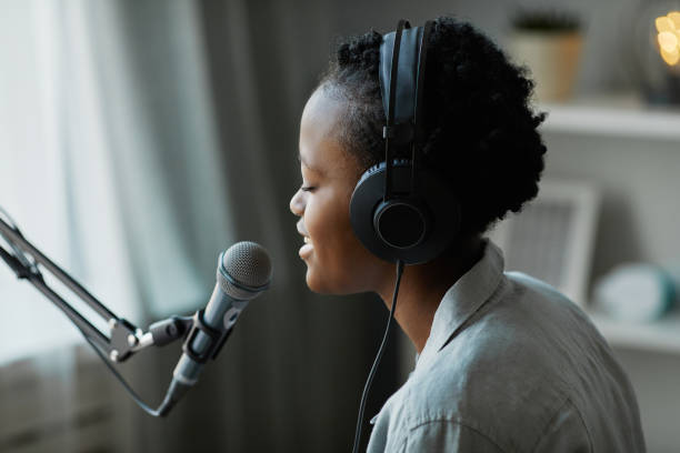 istock Young Black Woman Singing to Mic 1415362056