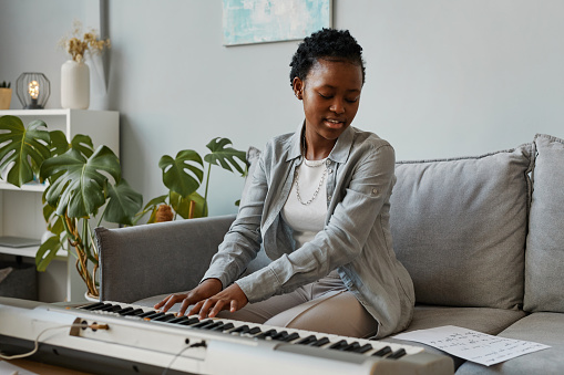 Smiling Woman Playing Digital Piano