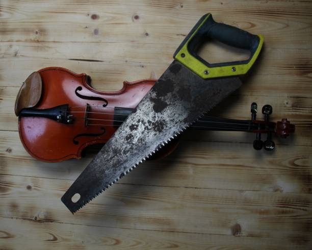 istock Violin and hacksaw on wooden background 1415362489