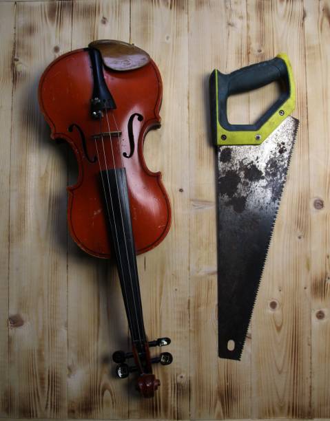 istock Violin and hacksaw on wooden background 1415362548