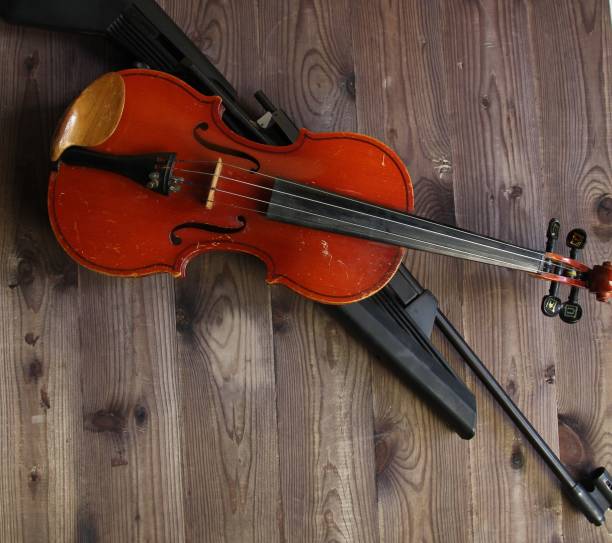 istock violin and dun on brown wooden background 1415362623