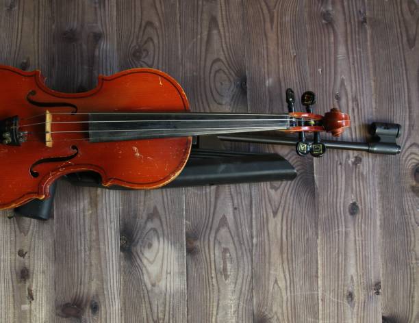 istock violin and dun on brown wooden background 1415362629