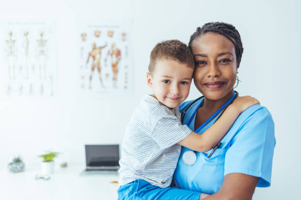 istock Female pediatrician with young patient looking at camera. 1415366023