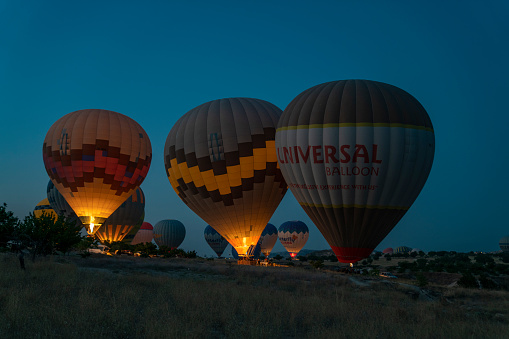 Cappadocia, Turkey - August 16 2022 - Stunning morning view and balloons in Cappadocia taking off at sunrise. Every day over 100 balloons fly taking tourist on a magical view of Nevsehir.