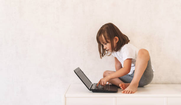 istock Girl sitting on the closet and using a laptop 1415367497