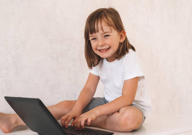 istock Smiling girl sitting on the closet and using a laptop 1415367502