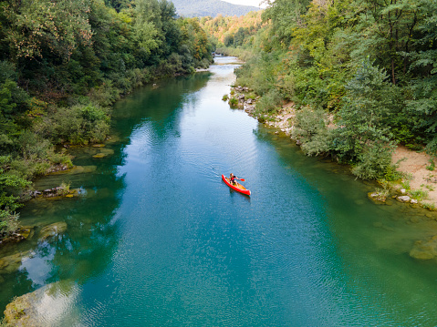 Drone Point of View on a Man Canoeing on Soca River in Slovenia in Summer.